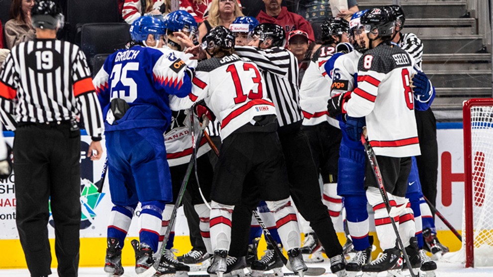Kanadskí (biele dresy) a slovenskí (modré dresy) hokejisti sa bijú počas zápasu A-skupiny Slovensko - Kanada na MS hráčov do 20 rokov.