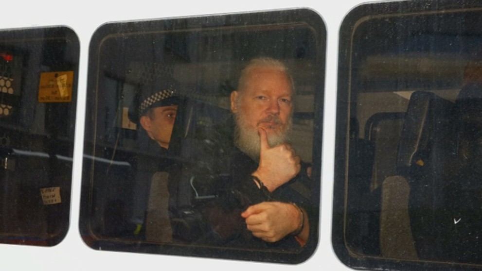 Julian Assange gestikuluje počas príchodu na súd po zatknutí v Londýne.