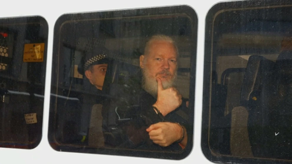 Julian Assange gestikuluje počas príchodu na súd po zatknutí v Londýne.