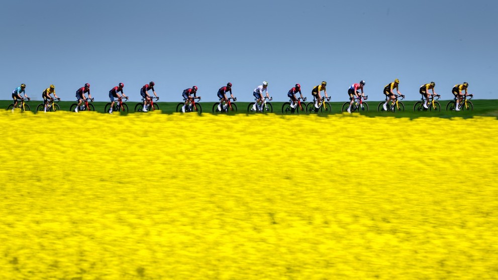 Skupina jazdcov prechádza okolo švajčiarskej dediny Echallens počas 4. etapy cyklistických pretekov Tour de Romandie.