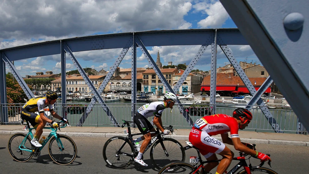 Cyklisti prechádzajú cez most poča 12. etapy Tour de France