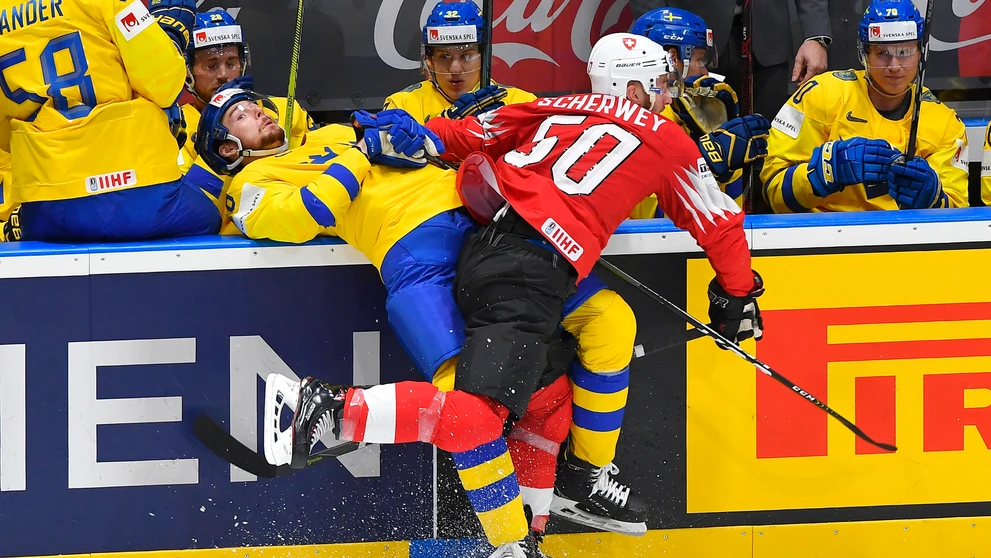Zľava Švéd John Klingberg a Švajčiar Philipp Kurashev v dueli na MS 2019.