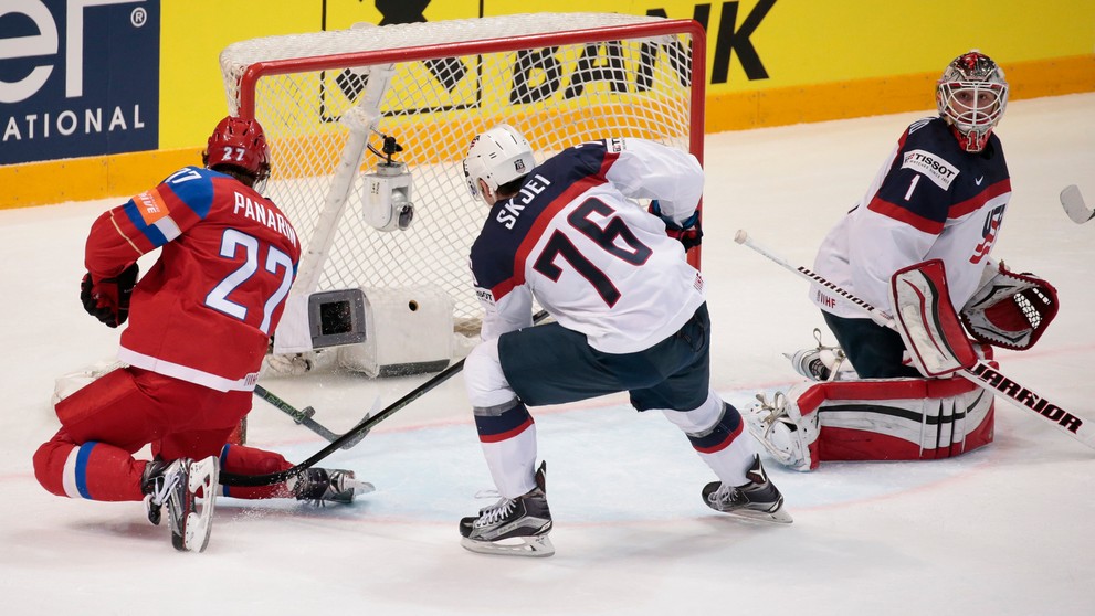 V súboji pri bránke ruský kanonier Artemij Panarin strieľa gól brankárovi USA Keithovi Kinkaidovi cez hráča USA Bradyho Skjeia v