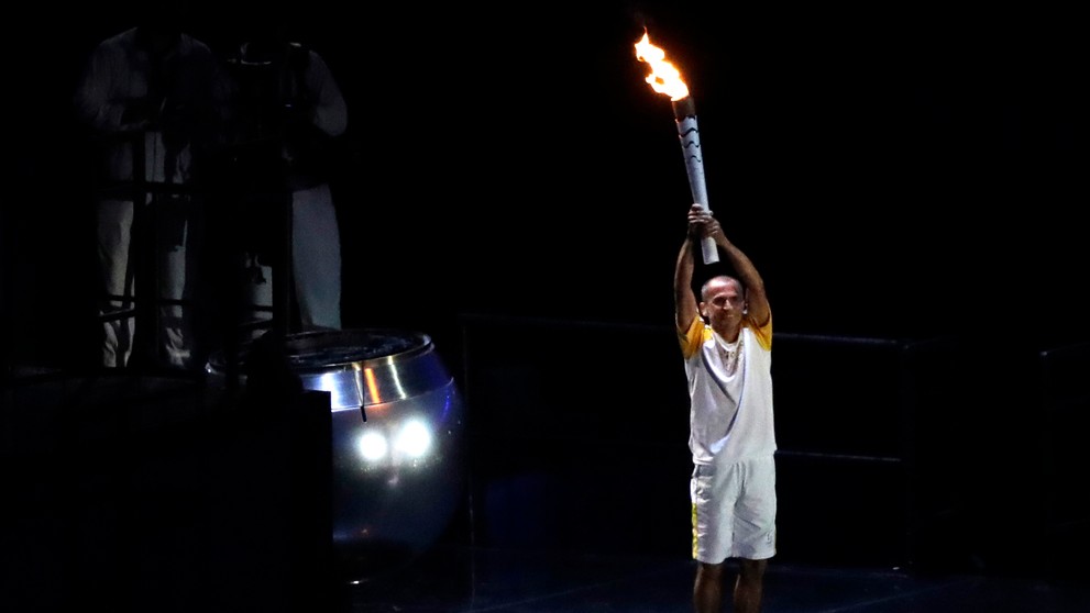 Bývalý maratónec Vanderlei Cordeiro de Lima zapaľuje olympijský oheň.