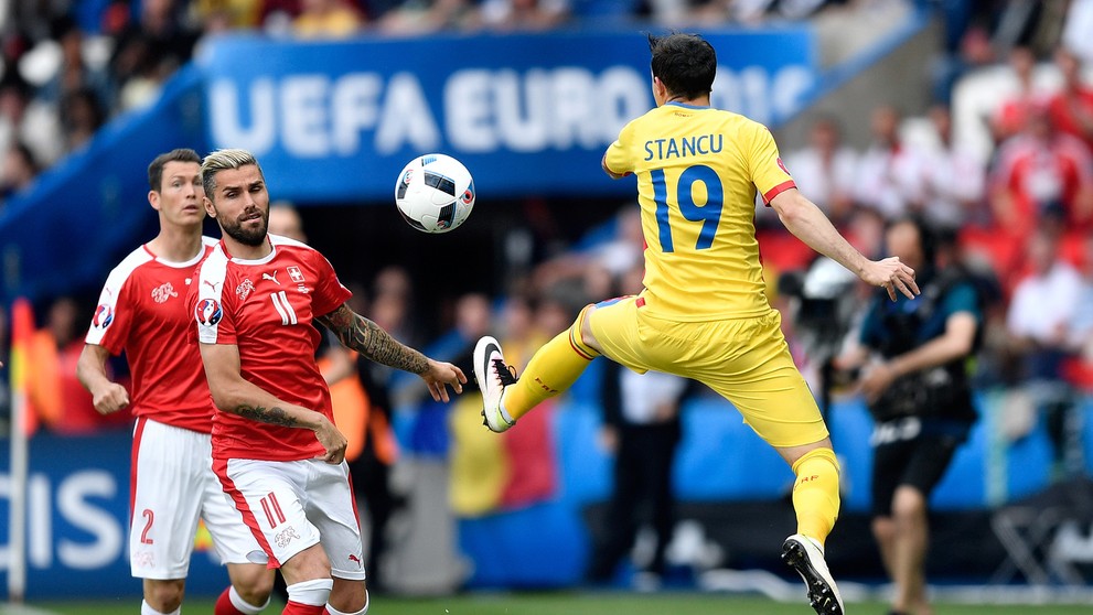 Rumun Bogdan Stancu (vpravo) a Švajčiar Valon Behrami bojujú o loptu na ME vo Francúzsku.