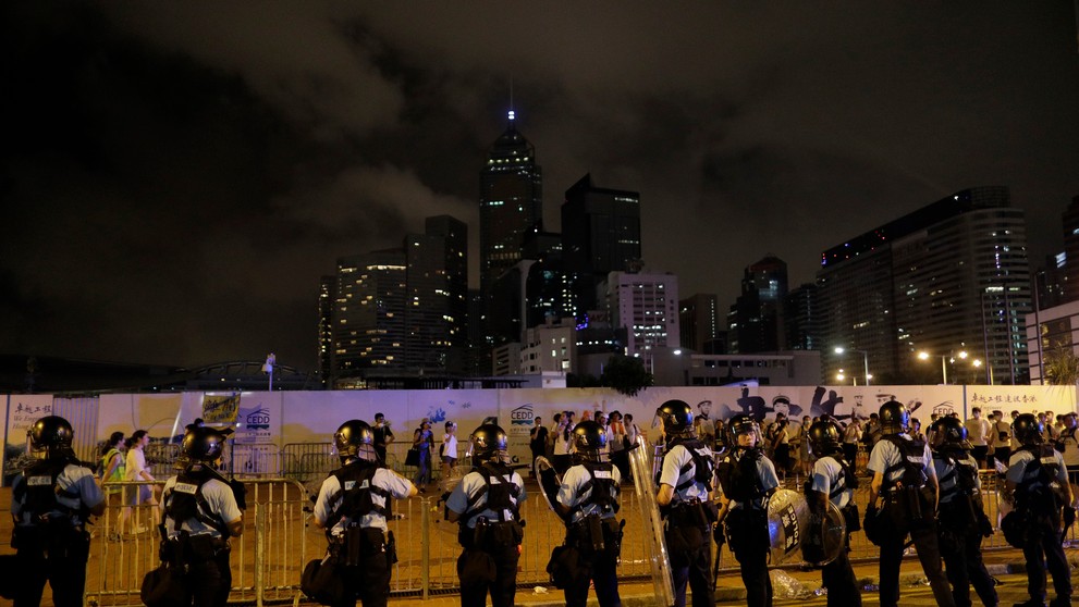 Policajti v Hongkongu zatýkajú počas protestu muža.