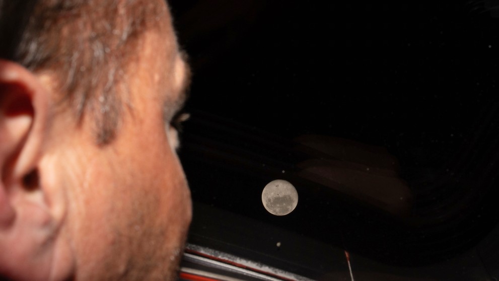 Veliteľ misie Artemis II a astronaut NASA Reid Wiseman sa pozerá na Mesiac z jedného z hlavných okien kabíny kozmickej lode Orion.