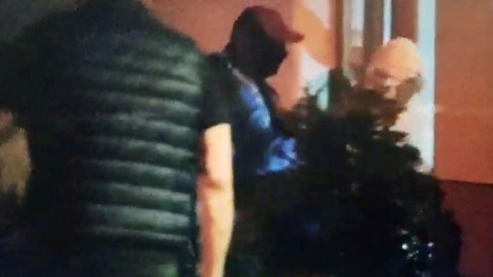 Podozrivý v sprievode policajtov vchádza na záchranársku stanicu.