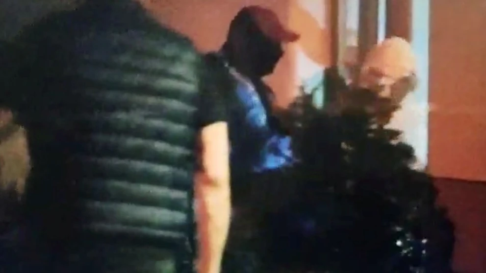 Podozrivý v sprievode policajtov vchádza na záchranársku stanicu.