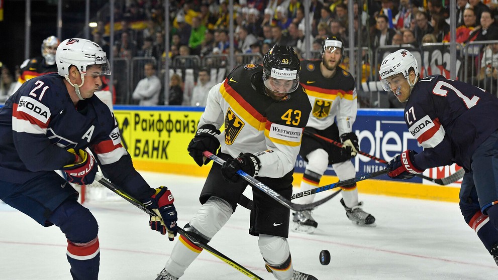 Američania Dylan Larkin (vľavo) a Anders Lee stíhajú Nemca Gerrita Fausera na MS 2017.