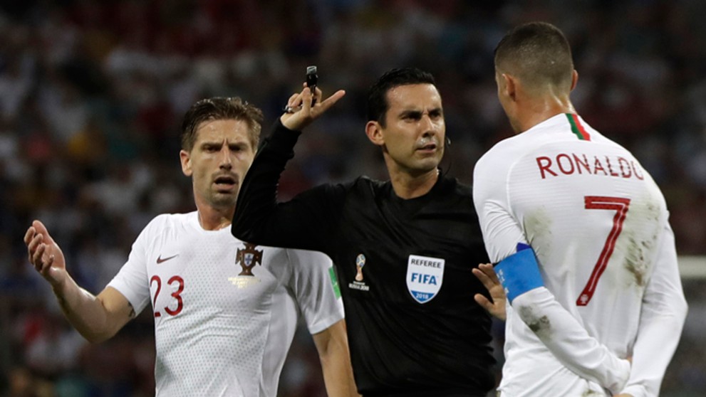 Cristiano Ronaldo a spoluhráč Adrien Silva v debate s mexickým rozhodcom Cesarom Ramosom.
