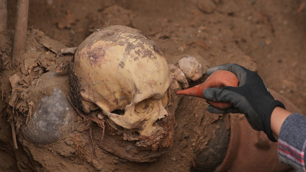 Archeológ skúma múmiu, ktorú náhodne objavila skupina robotníkov.