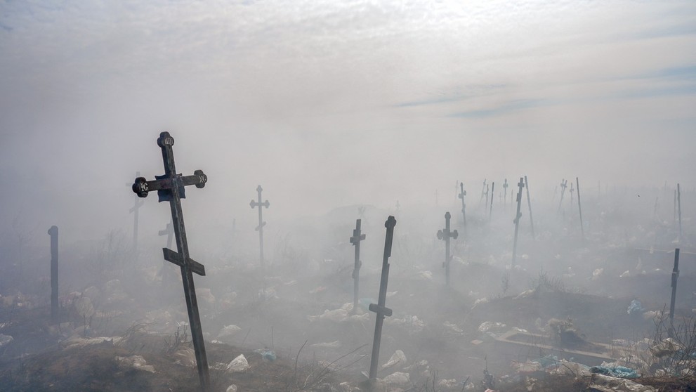 Kríže zahalené dymom z horiacich odpadkov na cintoríne vo vojnou zdevastovanom ukrajinskom meste Mykolajiv.