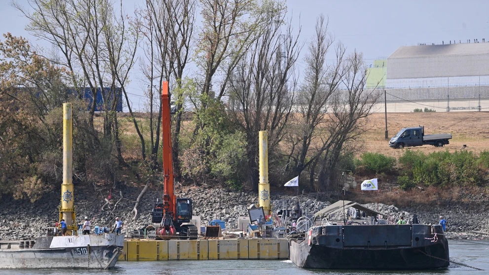 Ťažká technika asistuje pri riadenom potápaní dvoch 80 metrov dlhých člnov naložených kameňmi.