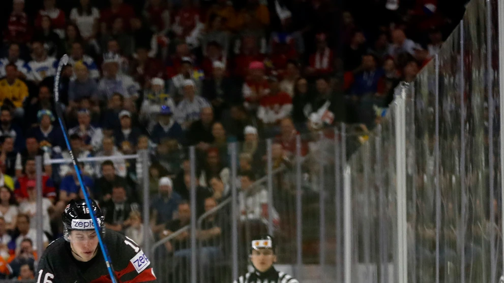 Kanaďan Mitch Marner vo výskoku a Švéd Elias Lindholm s pukom.