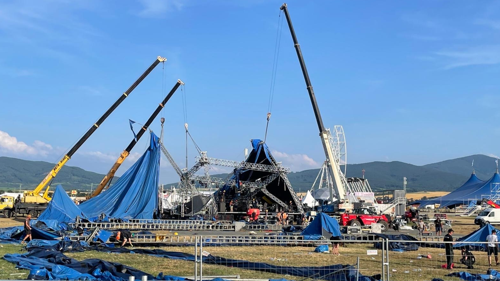 Žeriavy podopierajú zrútený stan na Pohode.