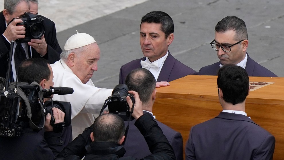 Pápež František sa dotýka truhly s pozostatkami zosnulého emeritného pápeža Benedikta XVI. po skončení pohrebnej omše
