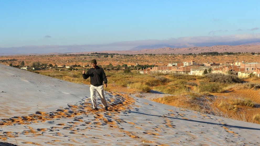 Alžírčan si užíva sneh, ktorý napadol na Sahare.