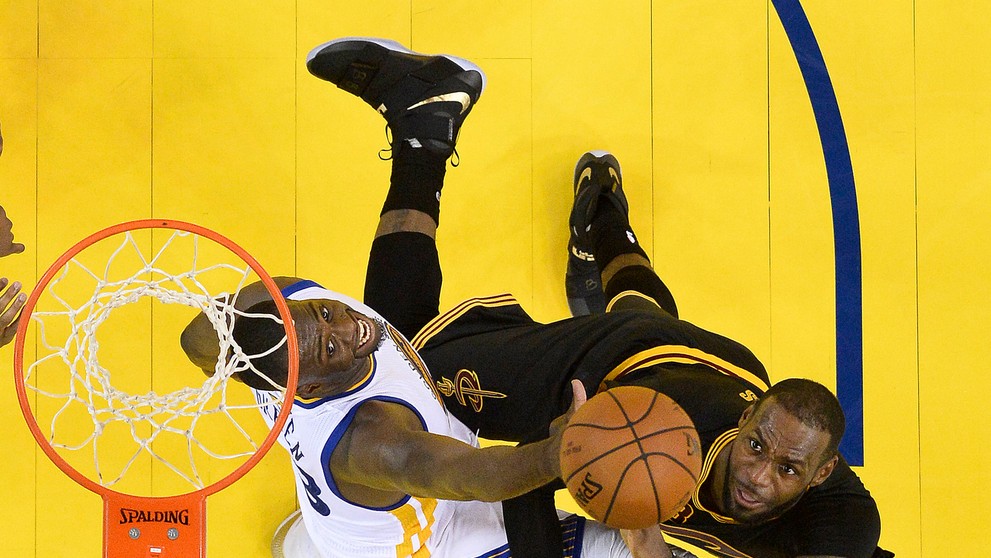 Draymond Green bojuje pod košom s LeBronom Jamesom.