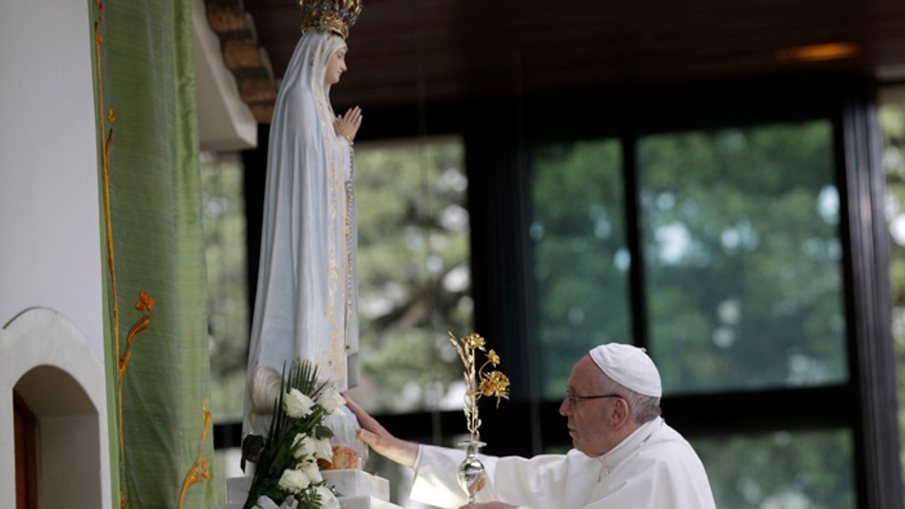 Pápež František sa dotýka sochy Panny Márie v svätyni na mieste jej zjavení v portugalskej Fátime.