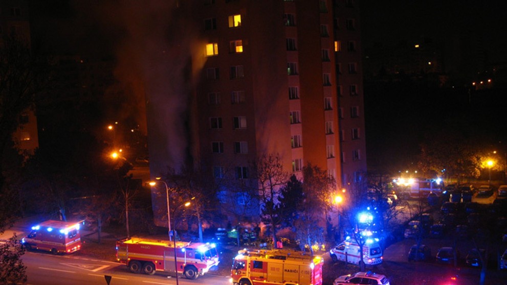 Záchranári a hasiči zasahujú počas požiaru, ktorý vypukol v byte na Bilíkovej ulici v Dúbravke.