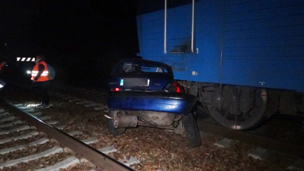 Zošrotované auto vlakom na trati v obci Kařízek na Rokycansku.