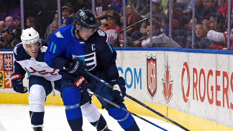 Kapitár Tímu Európy Slovinec Anže Kopitar si kryje puk pred Američanom Johnom Carlsonom.