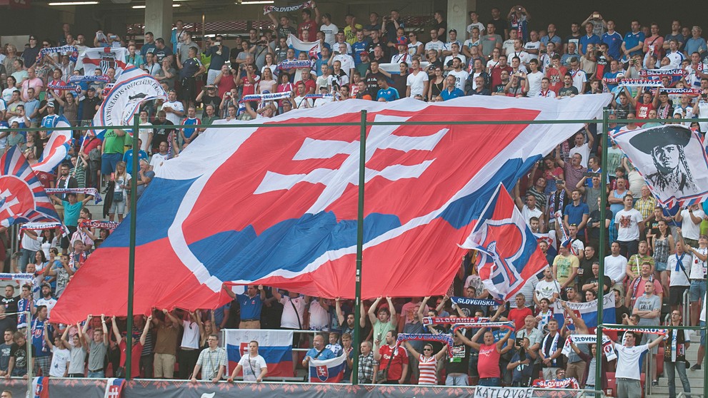 Slovenskí priaznivci so štátnou vlajkou počas duelu kvalifikácie MS 2018 proti Anglicku.