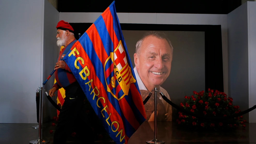 Fanúšik drží vlajku na počesť legendárneho holandského futbalistu, kapitána a trénera FC Barcelona Johana Cruyffa. 29. marca