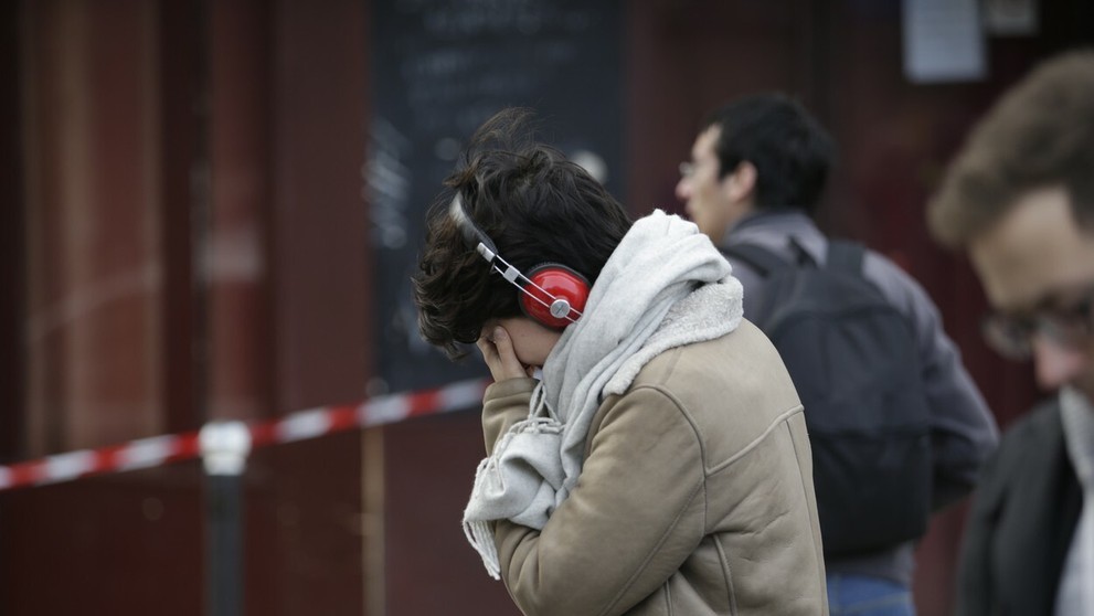 Plačúca žena pred barom Carillon, kde sa odohral jeden z útokov.