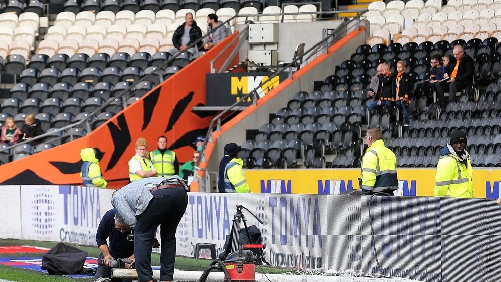 Robotníci upravujú bránky pred zápasom Hull - Birmingham.