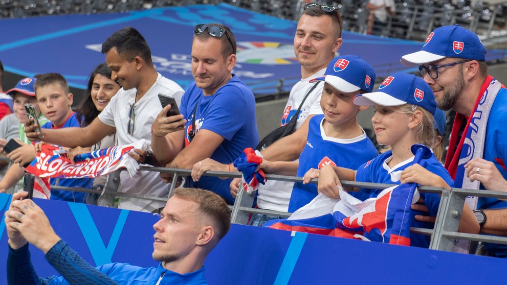 Ondrej Duda (dole) sa fotí s fanúšikmi po zápase s Rumunskom na ME 2024.