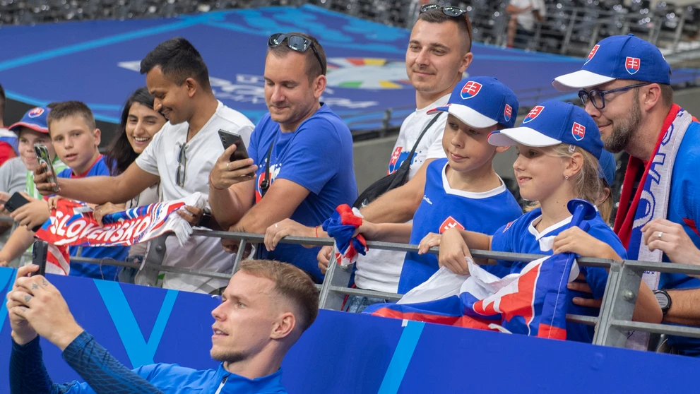 Ondrej Duda (dole) sa fotí s fanúšikmi po zápase s Rumunskom na ME 2024.