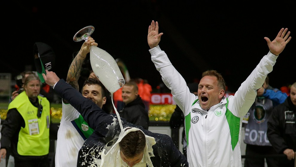 Portugalčan Vieirinha leje pivo na trénera Wolfsburgu Dietera heckinga po výhre vo finále Nemeckého pohára.