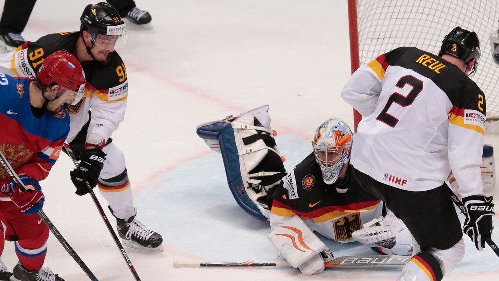 Rus Jevgenij Dadonov (vľavo) bojuje o puk s Nemcom Moritzom Müllerom (druhý zľava), brankárom Thomasom Greissom a Denisom Reulom