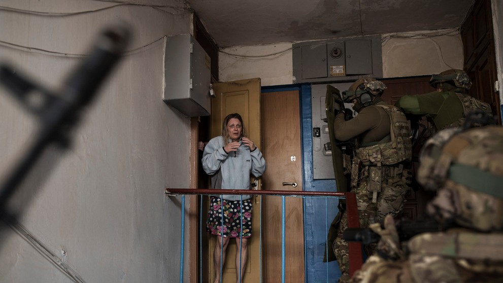 Vystrašená žena sa pozerá na príslušníkov ukrajinskej tajnej služby SBU, ktori prišli zadržať muža podozrivého z kolaborácie s Ruskom.