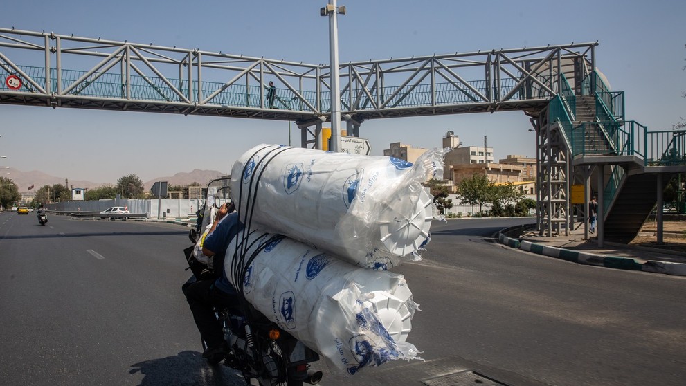 Motocykel prevážajúci vodné nádrže v deň, keď vláda uzavrela hlavné mesto kvôli nedostatku vody a výpadkom elektriny v Teheráne.