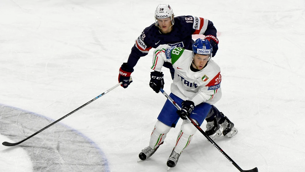 Američan Christian Dvorak (vzadu) naháňa v zápase MS 2017 Taliana Daniela Gliru.