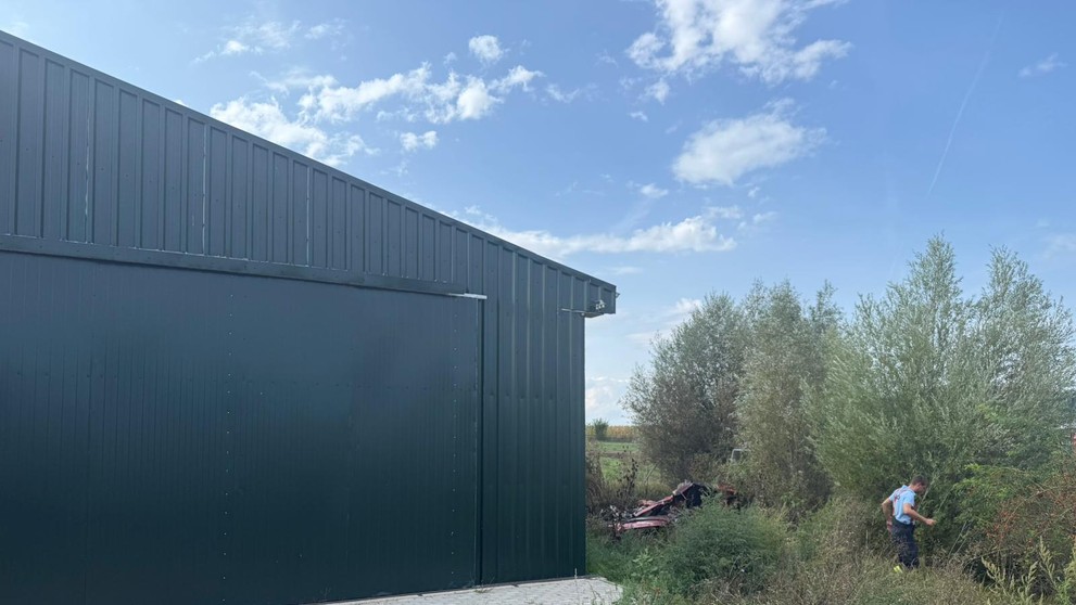 Lietadlo spadlo blízko haly.