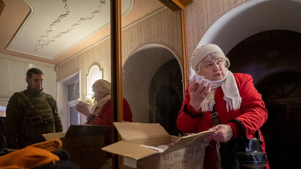 Galina Ivanovna odovzdáva Ivanovi materiál vyzberaný od dobrovoľníkov