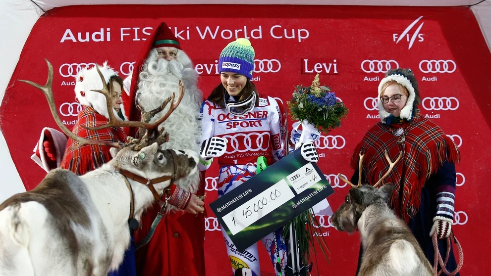 Petra Vlhová sa usmieva na pódiu so živými sobmi po prvom triumfe v slalome vo fínskom Levi z roku 2017.