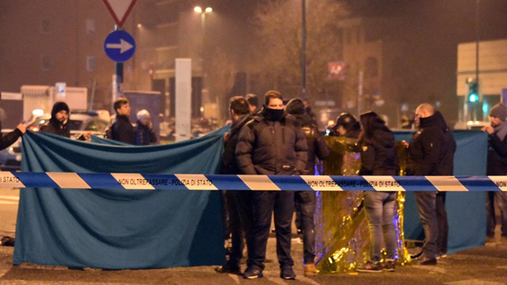 Policajti zakrývajú telo Anisa Amriho po tom, čo ho zastelili muži zákona v meste Sesto San Giovanni.