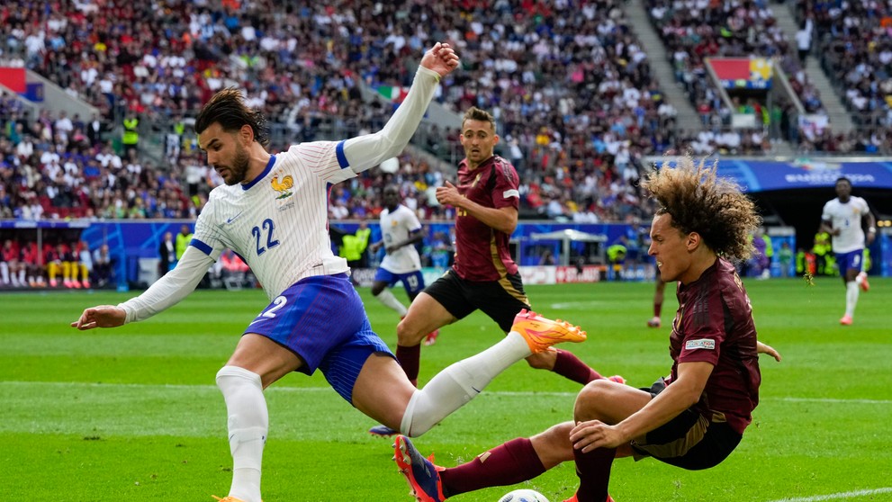 Zľava Francúz Theo Hernandez a Belgičan Wout Faes v osemfinále ME 2024.