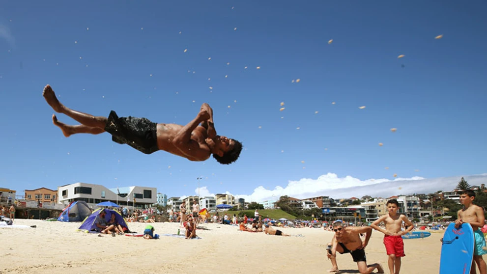 Brazílsky akrobat Jackson Carmelo Topazio na austrálskej pláži Bondie Beach.