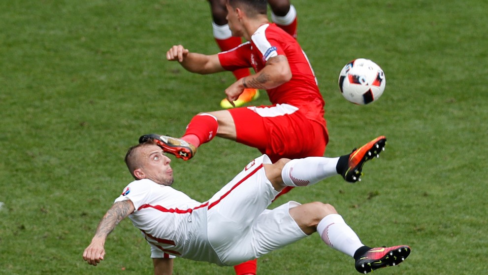 Hráč Poľska Kamil Grosicki pri akrobatickom pokuse o streľbu v osemfinále ME proti Švajčiarsku