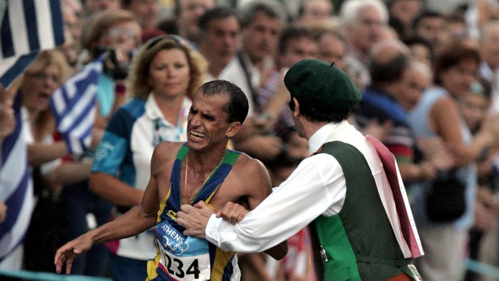 Jeden z divákov napadá favorita pretekov, brazílskeho atléta Vanderleia De Limu, v poslednom úseku maratónskej trate v Aténach.