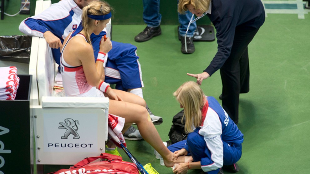 Fyzioterapeutka Dorota Olaszová ošetruje nohu Anne Karolíne Schmiedlovej počas stretnutia so Samanthou Stosurovou.