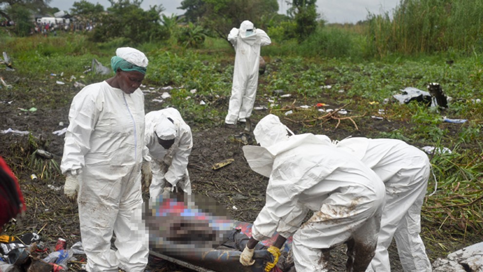Záchranári nakladajú mŕtve telo pasažiera z havarovaného lietadla pri meste Džuba.