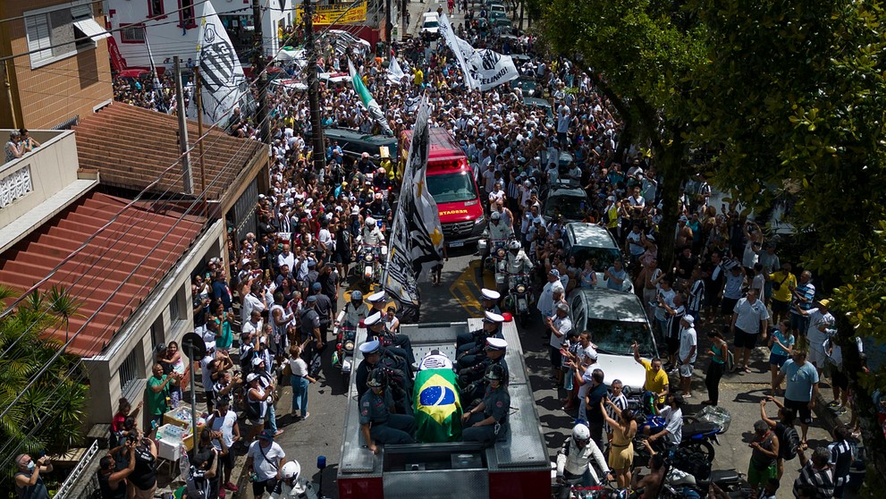 Rakva s pozostkami zosnulého brazílskeho legendárneho futbalistu Pelého je zakrytá brazílskou vlajkou a vlajkou klubu Santos FC počas prevozu zo štadióna Vila Belmiro na cintorín Memorial Necropole Ecumenica.