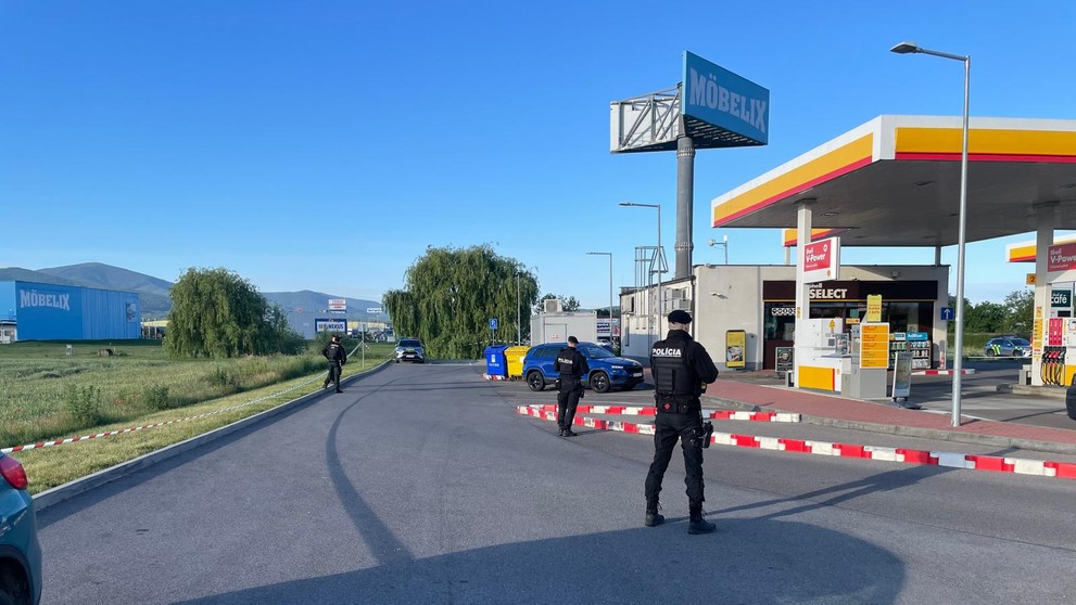 Policajti hliadkujú pred čerpačkou.